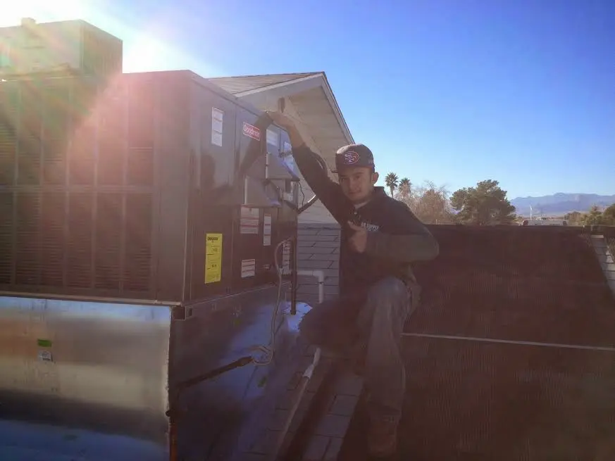 HVAC technician performing Air Duct Repair on a rooftop unit in McLendon-Chisholm